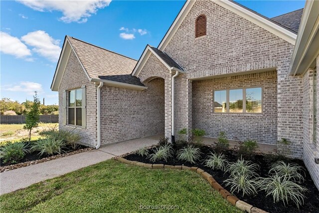 2160 Madden Cir, College Station, TX 77845 - view of front of home with brick siding, a shingled roof, and a front yard