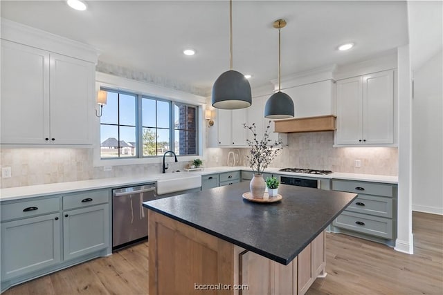 2160 Madden Cir, College Station, TX 77845 - kitchen featuring stainless steel appliances, a sink, light wood-style flooring, pendant lighting, and decorative backsplash
