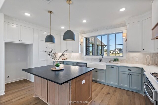 2160 Madden Cir, College Station, TX 77845 - kitchen with light wood-style flooring, stainless steel dishwasher, backsplash, a kitchen island, and recessed lighting