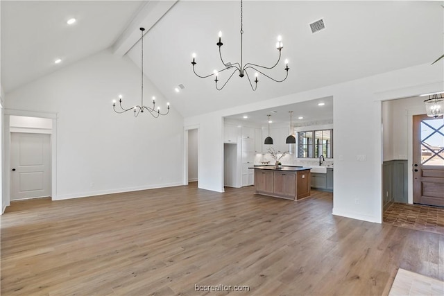 2160 Madden Cir, College Station, TX 77845 - unfurnished living room featuring a chandelier, high vaulted ceiling, beam ceiling, light wood finished floors, and a sink