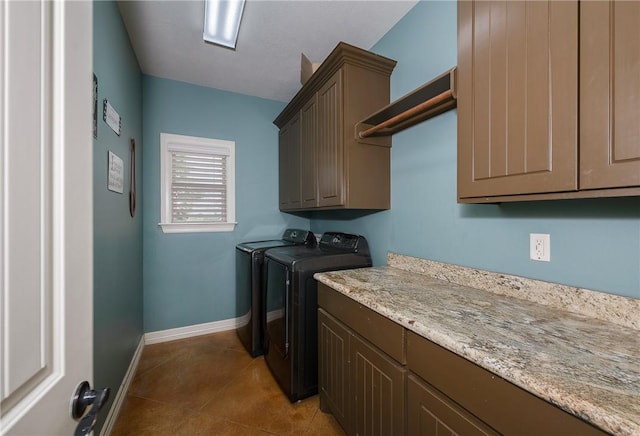 laundry area featuring baseboards, cabinet space, tile patterned floors, and washing machine and clothes dryer