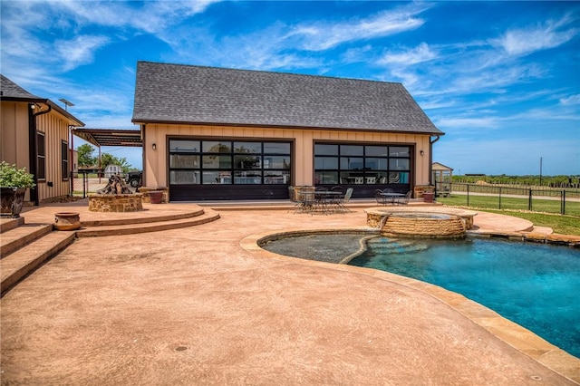 view of swimming pool featuring fence, an outdoor structure, a pool with connected hot tub, and a patio area