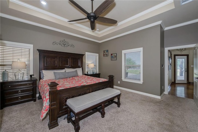 bedroom featuring crown molding, a raised ceiling, baseboards, and carpet flooring