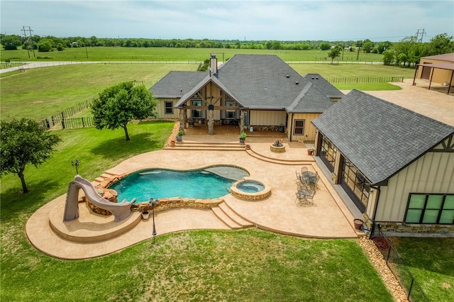 view of pool with fence private yard, a patio area, a water slide, a yard, and a pool with connected hot tub