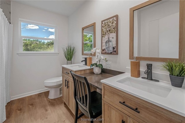 bathroom with hardwood / wood-style floors, vanity, and toilet