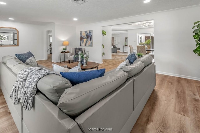 living room with light wood-type flooring and a textured ceiling