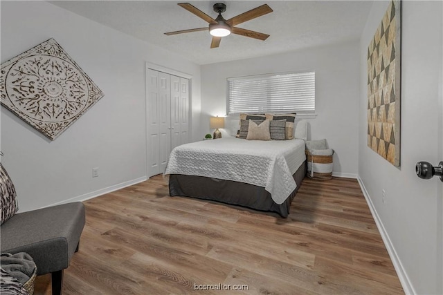 bedroom with ceiling fan, a closet, and hardwood / wood-style flooring