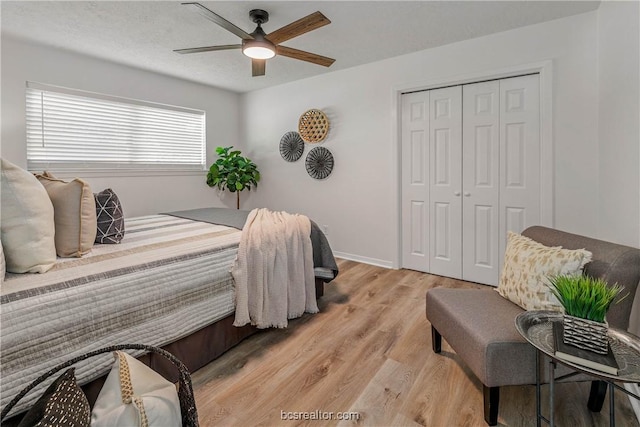 bedroom with a closet, ceiling fan, and light hardwood / wood-style floors