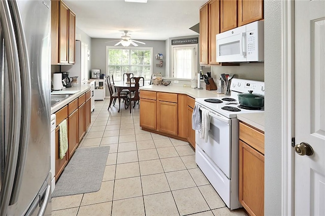 713 Broadmoor Dr, Bryan, TX 77802 - kitchen with white appliances, light tile patterned floors, ceiling fan, light countertops, and a peninsula