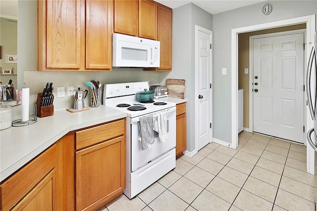 713 Broadmoor Dr, Bryan, TX 77802 - kitchen featuring white appliances, light tile patterned flooring, light countertops, and baseboards