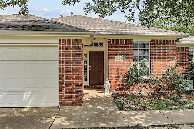 713 Broadmoor Dr, Bryan, TX 77802 - property entrance featuring brick siding, roof with shingles, and an attached garage
