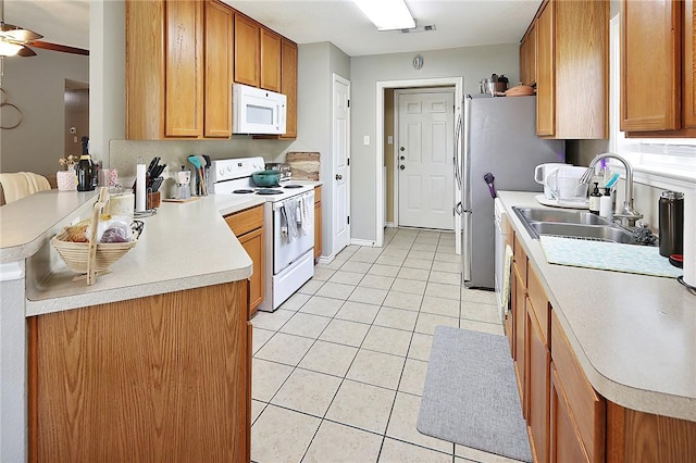 713 Broadmoor Dr, Bryan, TX 77802 - kitchen featuring white appliances, light tile patterned floors, a sink, light countertops, and a peninsula