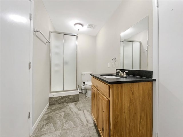 bathroom with vanity, a shower with shower door, and toilet