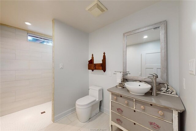 bathroom featuring tile patterned floors, vanity, toilet, and tiled shower