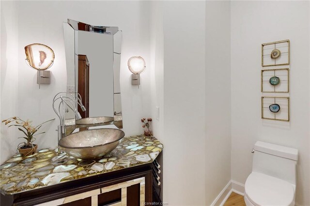 bathroom featuring hardwood / wood-style floors, vanity, and toilet