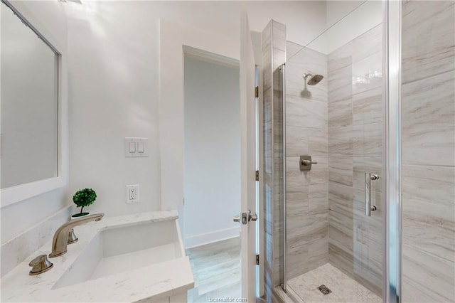 bathroom with hardwood / wood-style floors, vanity, and a shower with shower door