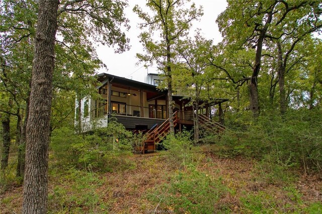 rear view of house with a sunroom and ceiling fan