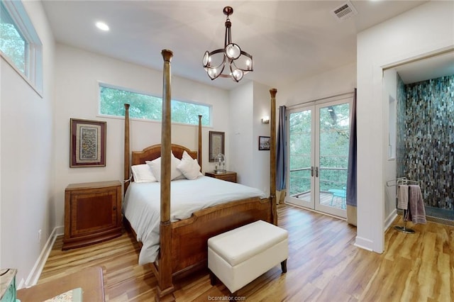 bedroom featuring a notable chandelier, access to exterior, light wood-type flooring, and french doors