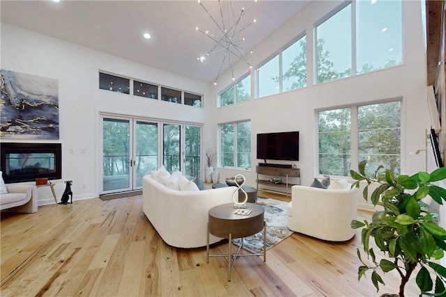 living room with light wood-type flooring and a high ceiling