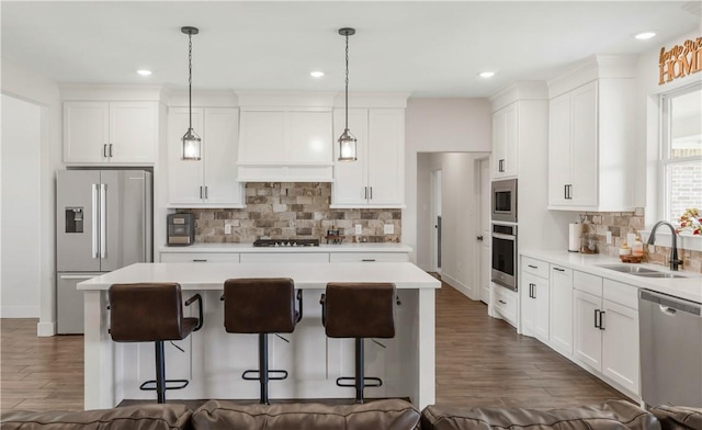 10146 Henley Cv, Iola, TX 77861 - kitchen featuring stainless steel appliances, a sink, a breakfast bar, dark wood-style floors, and a kitchen island