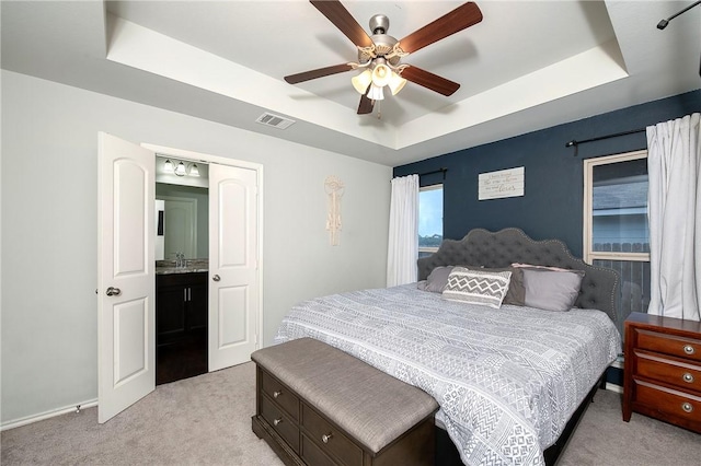 122 Dove Ct, Navasota, TX 77868 - bedroom featuring light colored carpet, a tray ceiling, and ceiling fan