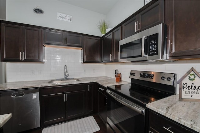 122 Dove Ct, Navasota, TX 77868 - kitchen with appliances with stainless steel finishes, tasteful backsplash, light stone countertops, and dark brown cabinets