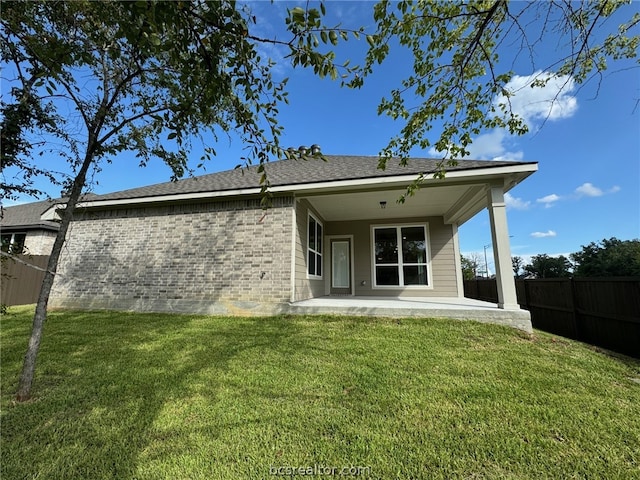 rear view of house featuring a patio area and a yard