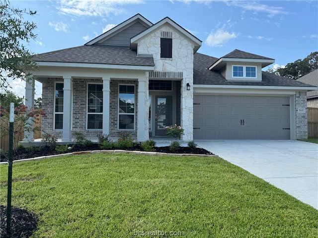 view of front of home with a front yard and a garage