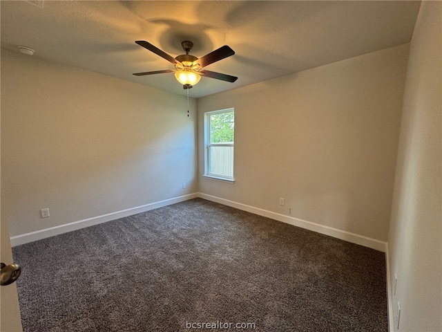 empty room featuring dark carpet and ceiling fan