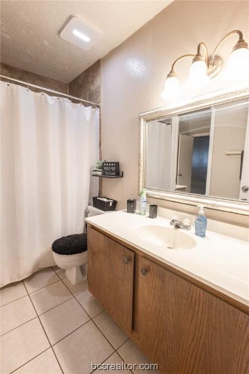 bathroom featuring tile patterned flooring, vanity, a textured ceiling, and toilet