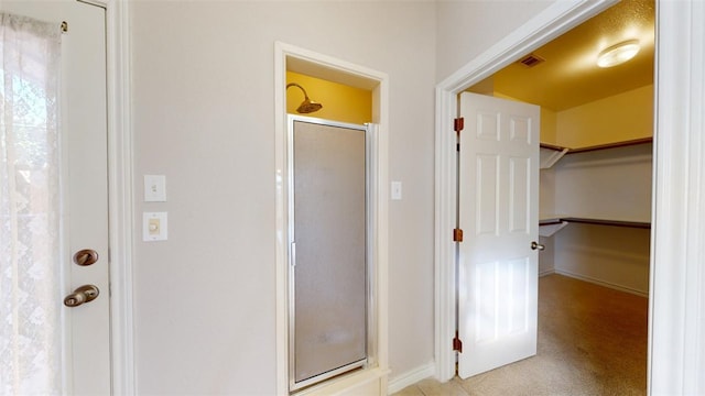 bathroom with visible vents and a shower with shower door