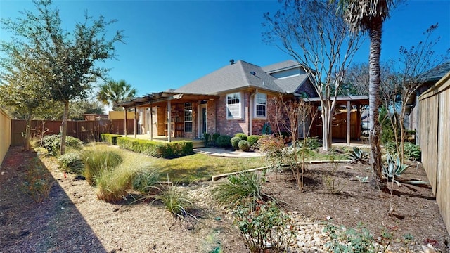 exterior space featuring a fenced backyard and brick siding