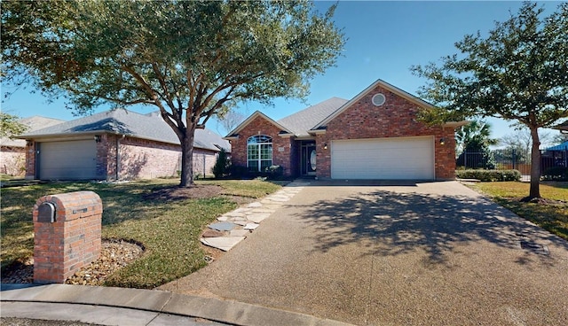 ranch-style house featuring fence, driveway, a front lawn, a garage, and brick siding