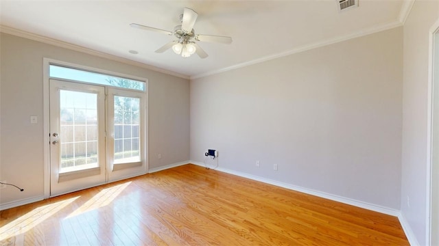 empty room featuring baseboards, light wood finished floors, and crown molding