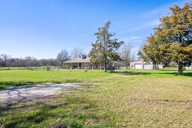 view of yard with an outbuilding, a rural view, and a garage