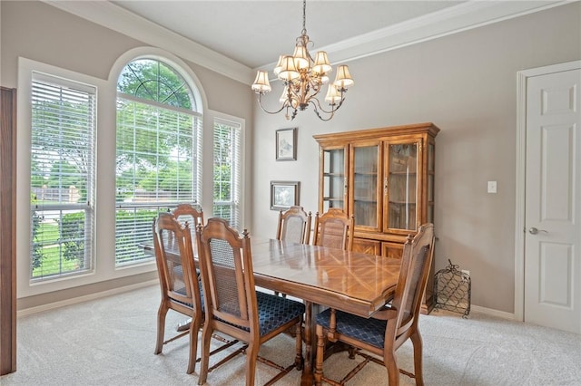 dining area with crown molding, baseboards, a notable chandelier, and light carpet