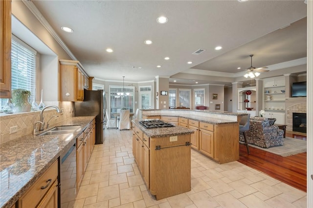 kitchen featuring visible vents, ornamental molding, a large island, a sink, and stainless steel appliances
