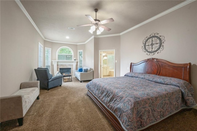 carpeted bedroom with a ceiling fan, visible vents, crown molding, a fireplace, and ensuite bathroom
