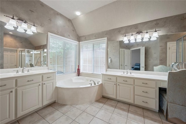 full bath featuring a garden tub, tile patterned floors, a sink, a stall shower, and vaulted ceiling