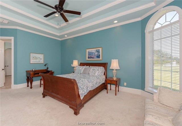 carpeted bedroom with arched walkways, ceiling fan, baseboards, ornamental molding, and a raised ceiling