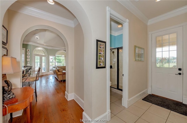 entryway with french doors, light wood-type flooring, and ornamental molding