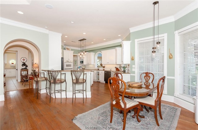 dining space featuring light hardwood / wood-style floors and ornamental molding