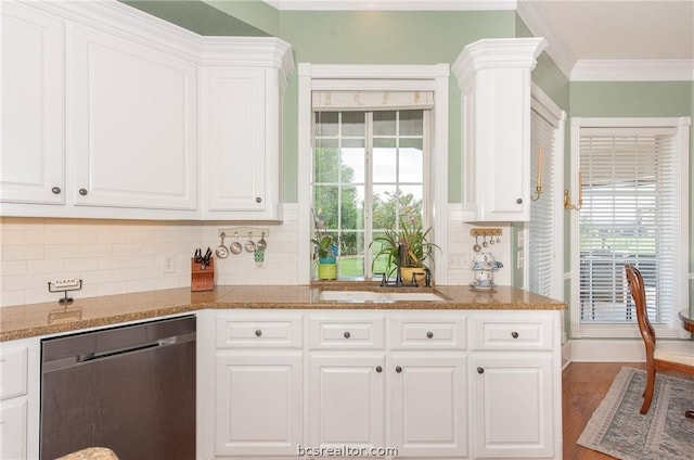 kitchen with stainless steel dishwasher, white cabinets, sink, and tasteful backsplash