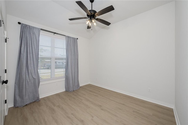 spare room featuring ceiling fan, light wood-type flooring, and vaulted ceiling