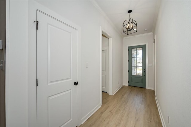 entryway featuring a chandelier, crown molding, and light hardwood / wood-style floors