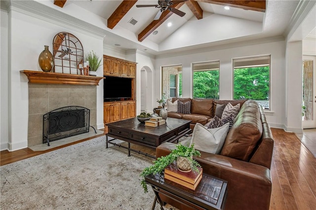 3281 Toltec Trl, College Station, TX 77845 - living room featuring wood-type flooring, a ceiling fan, arched walkways, and a fireplace