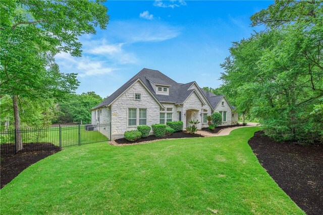 3281 Toltec Trl, College Station, TX 77845 - french provincial home featuring fence, stone siding, and a front lawn