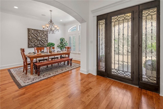 3281 Toltec Trl, College Station, TX 77845 - foyer entrance with a notable chandelier, arched walkways, recessed lighting, baseboards, and light wood-type flooring