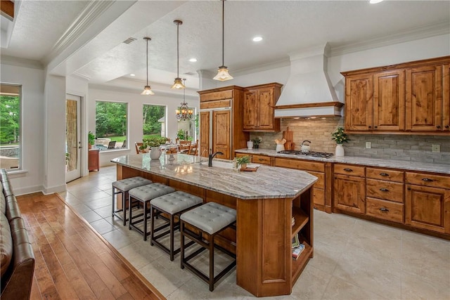 3281 Toltec Trl, College Station, TX 77845 - kitchen with plenty of natural light, custom range hood, brown cabinets, and tasteful backsplash