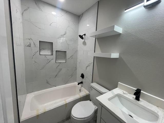 full bathroom with vanity, toilet, and tiled shower / bath